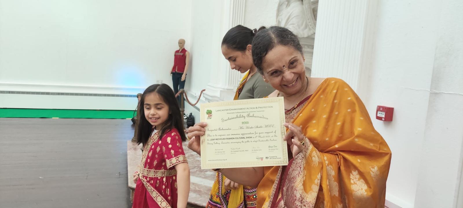 Harsha holding her Sustainability Ambassadors certificate