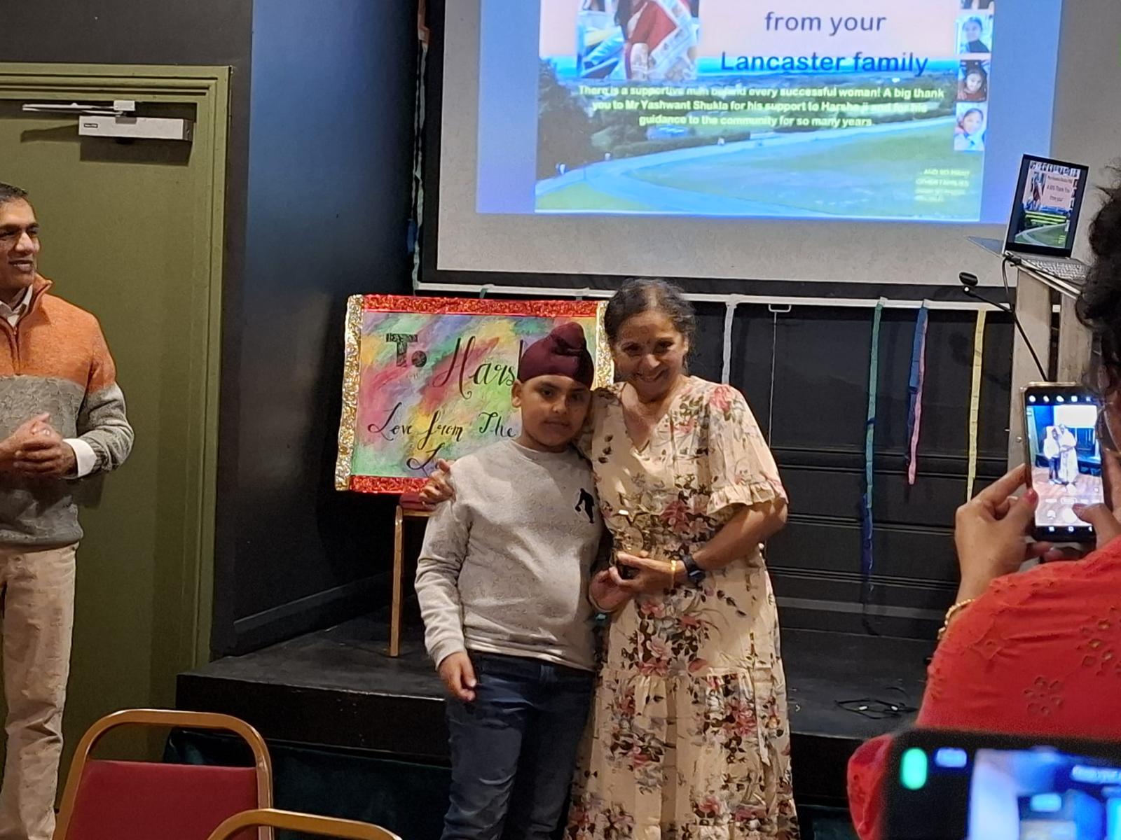 Harsha receiving a gift from a young member of the community